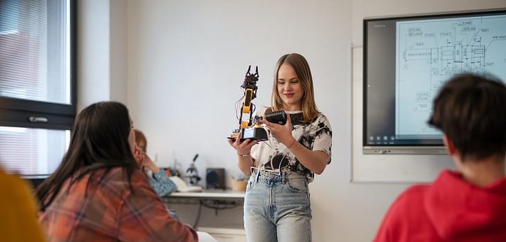 Young High school student is presenting her robotic project in classroom